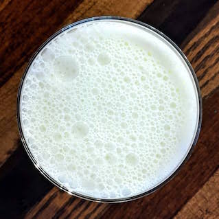 Photograph of a glass of milk with a splash of cream